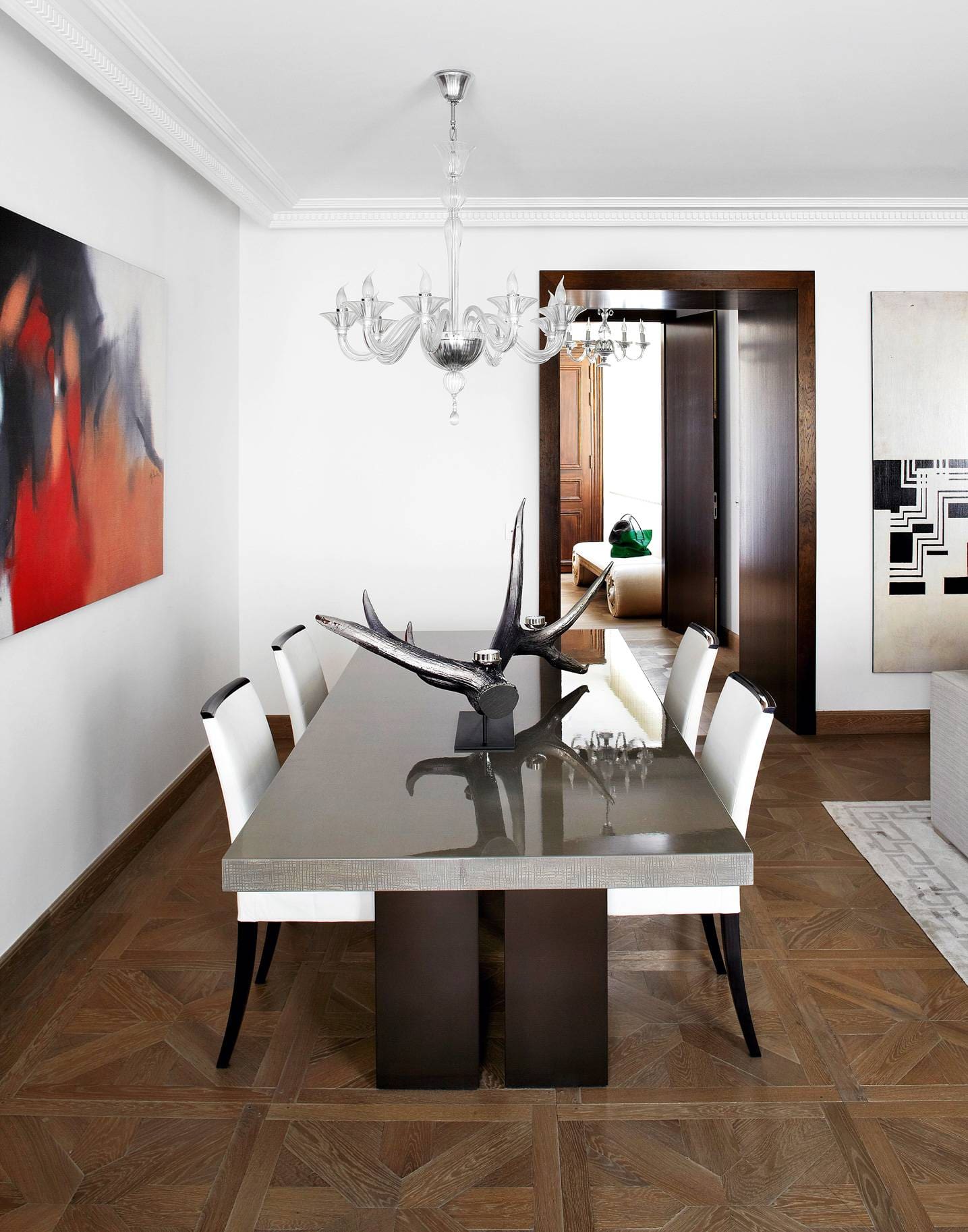 Table de salle à manger  « Trocadero » d’Armani Casa, chaises BC Bertrand, bougeoirs bois de cerf wapiti en résine et argent teinté noir (Mellerio).